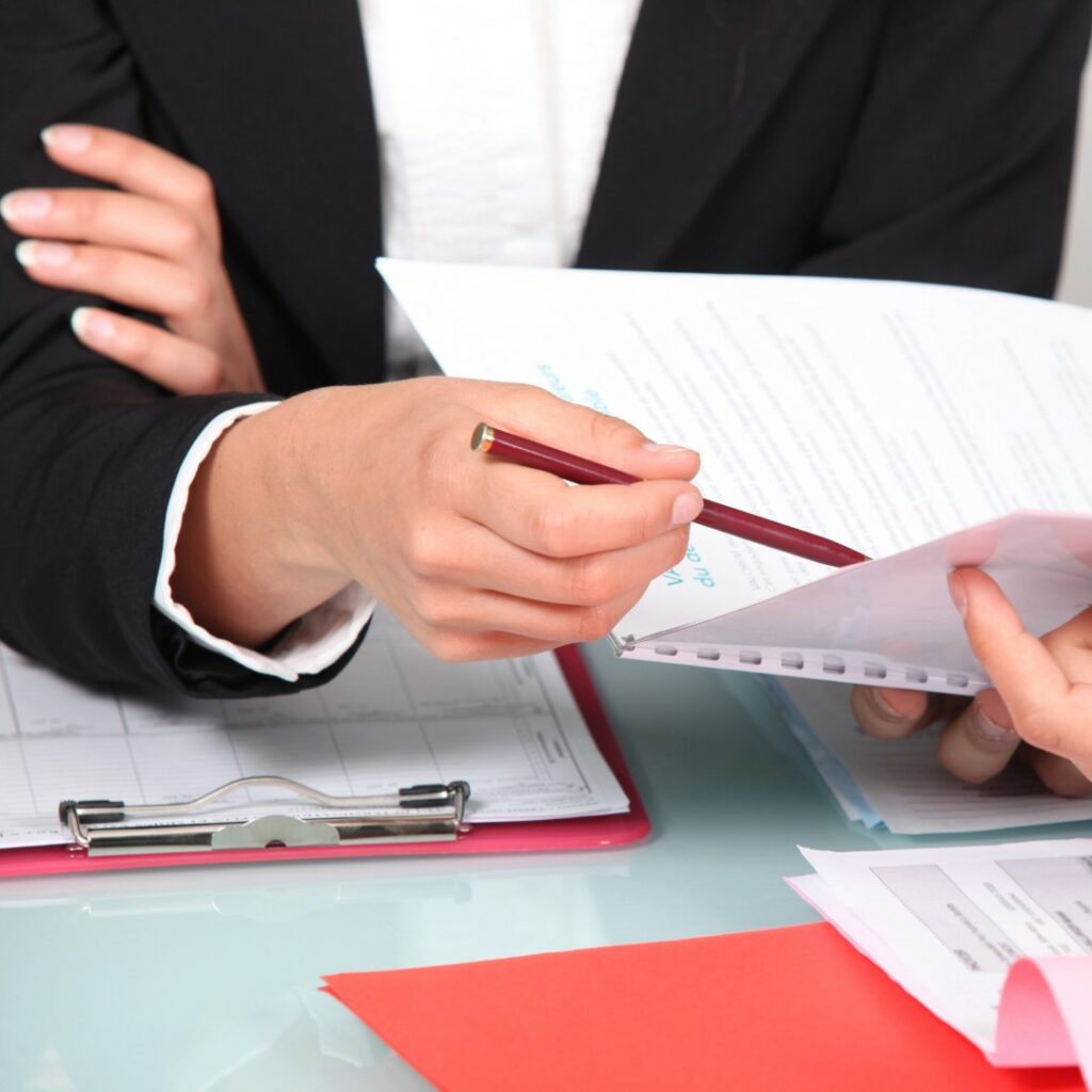 Mani di due persone che esaminano documenti durante una consulenza