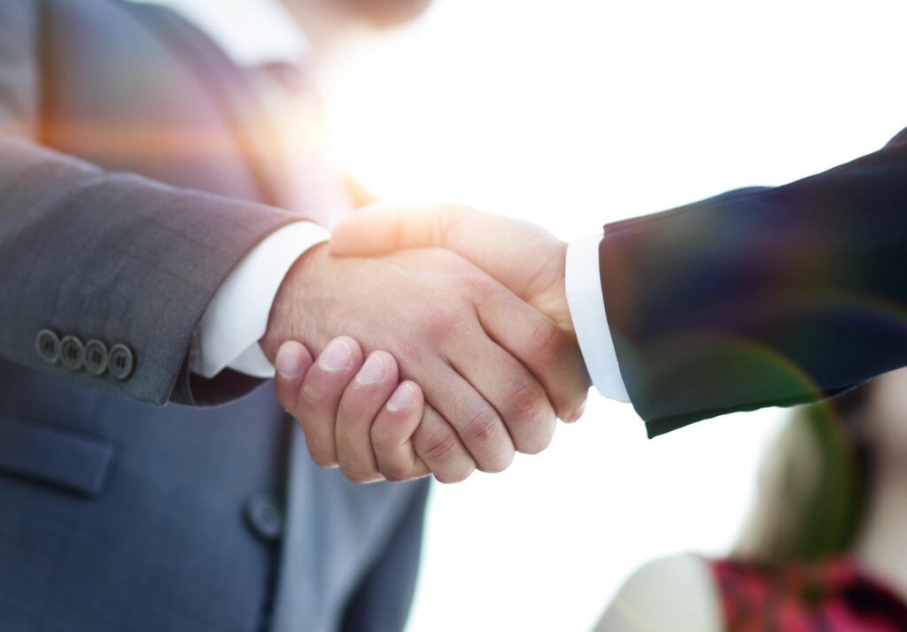 Stretta di mano tra due uomini d'affari in abito elegante, simbolo di accordo o collaborazione professionale
