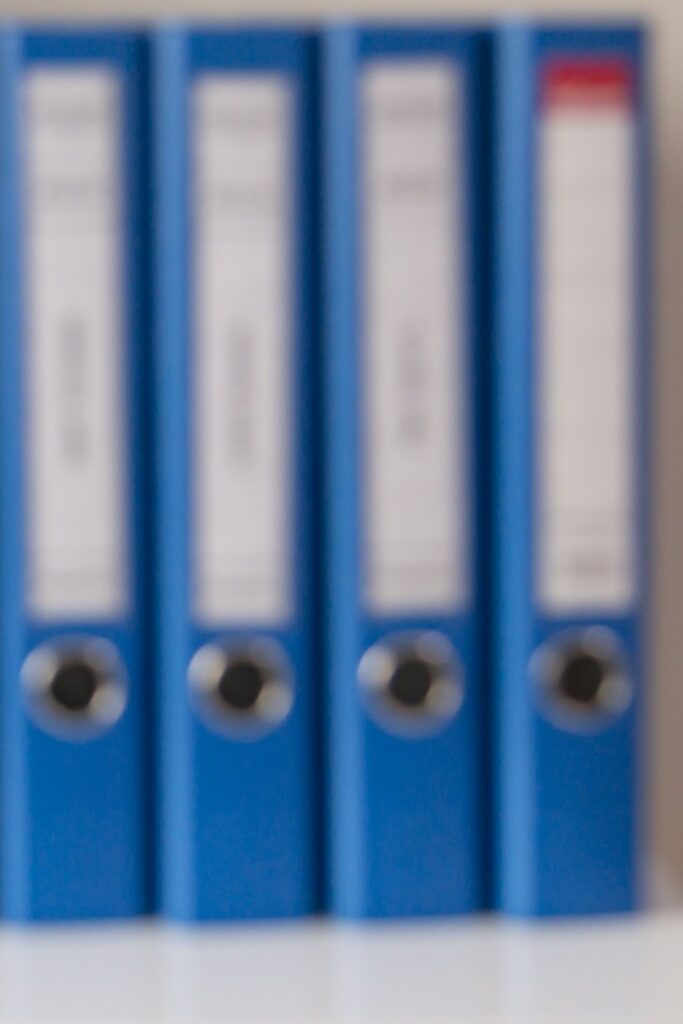 Raccoglitori blu ordinati su uno scaffale, simbolo di archivio organizzato